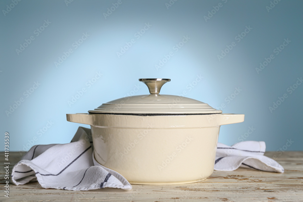 Cooking pot on table against color background