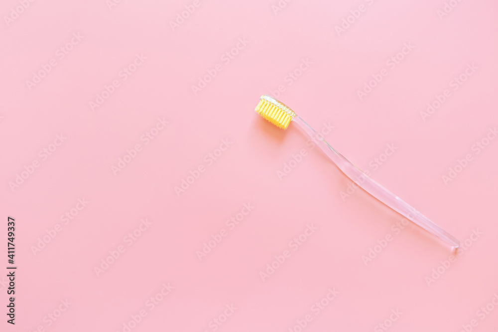 Toothbrush with yellow bristles on a pink background. Oral hygiene ...