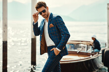 Young Handsome Man In Classic Suit Wear Sunglasses Over The Blurred Lake