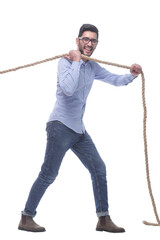 purposeful young man pulls the rope. isolated on a white background.