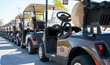 Background Image Of Multiple Golf Carts Parked In Order.