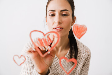 Beautiful smiling young woman in love drawing hearts