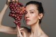 © Drobot Dean - Beautiful half-naked woman posing with bunch of grapes