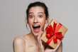 © Drobot Dean - Excited half-naked woman screaming while showing gift box