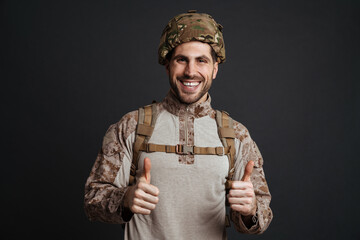 Wall Mural - Happy military man wearing helmet smiling and showing thumb up