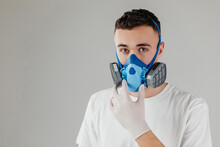 A Man In A Respirator Mask With An Increased Degree Of Protection Against Harmful Environmental Factor, Chemicals Or Covid19. Full Face Mask. Isolated On A Grey Background.