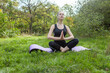 © splitov27 - Fit woman in sportswear is practicing yoga while sitting on the mat outdoors. Meditation.