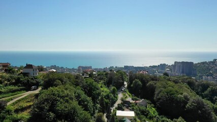 Wall Mural -  Aerial Drone shot with an amazing view Sochi. Aerial view. Cityscape. Shooting from above panorama of amazing touristic city resort with mountain and sea.