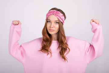 Closeup portrait of young beautiful woman with rising hands. Trendy girl in casual pink hoodie. People lifestyle concept