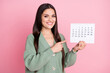© deagreez - Photo of lady hold calendar direct finger date wear green cardigan isolated pastel pink color background