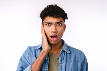 shocked young mixed-race man in casual attire isolated over white