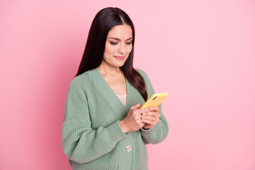 Poster - Photo of charming girl hold telephone look screen wear green cardigan isolated pastel pink color background