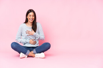 Wall Mural - Young caucasian woman isolated on pink background smiling a lot