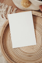 White Invitation Cards In A Wooden Wicker Basket In Boho Style