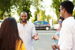 © etonastenka - Young people having fun outdoors. A group of multi-ethnic friends are talking and laughing while standing in the street