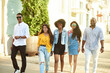 © etonastenka - Smiling multiethnic diverse friends speak walking on the street. Communication concept