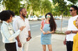 © etonastenka - Young people having fun outdoors. A group of multi-ethnic friends are talking and laughing while standing in the street