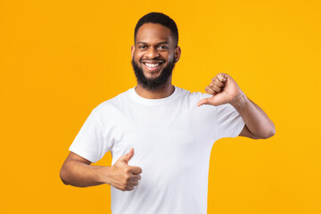 Cheerful Black Guy Pointing Thumbs At Himself On Yellow Background