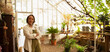 © Martin Barraud/Caia Image - Portrait confident female florist in greenhouse shop