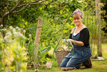Portrait Confident Woman Harvesting Fresh Leeks In Garden