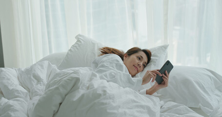 Poster - Woman use of cellphone and laid on bed