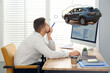 © New Africa - Man dreaming about new car in office