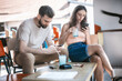 © guruXOX - Alienation addiction. Young couple sitting in cafe and typing on their own phones