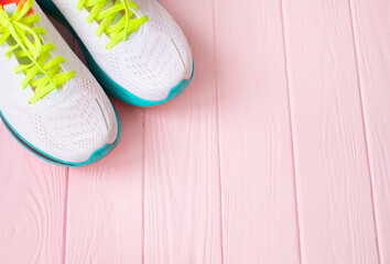 White sneakers on light pink background. Stylish white sneakers.