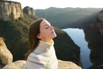 Wall Mural - Woman breathing fresh air in a cliff in the mountain