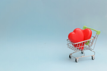 Happy Valentine's Day or Mother's Day greeting card with red hearts in a shopping cart on blue background.Banner for your store or website.Copy space.Mock up.