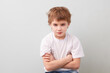© ulza - thoughtful sad schoolboy in a white T-shirt on a gray background