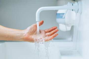 Wall Mural - hand under the faucet with flowing water splash