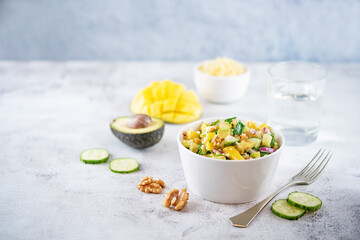 Millet mango avocado cucumber salad in a bowl