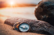 Alter nautischer Kompass am Strand im Sonnenuntergang