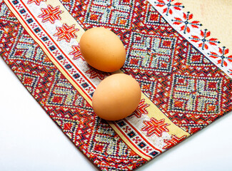 two chicken eggs on a folk towel