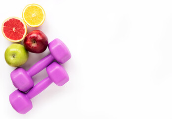 Fresh fruits for healthy eating and sports equipment (purple female kettlebells) Healthy food and sports concept