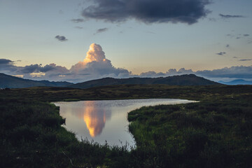 Wall Mural - scenic sunset landscape with yellow big cloud in form of explosion above mountain lake. awesome gian
