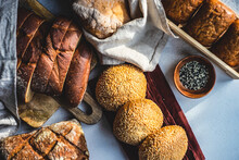 Overhead View Of A Variety Of Bread Rolls And Loaves Of Bread With Sesame Seeds