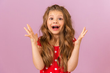 Wall Mural - A curly-haired little girl in a red dress shows her joy.