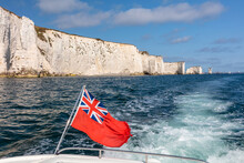 British Red Ensign Flag On Boat Sailing Past Old Harry Rocks, Dorset, England