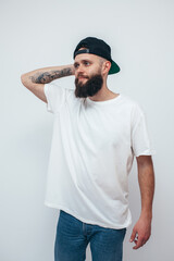 Sticker - Young bearded hipster guy wearing white oversized blank t-shirt on a white background. Mock-up for print. T-shirt design and advertising concept.