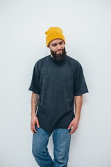 Canvas Print - Young bearded hipster guy wearing gray oversized blank t-shirt on a white background. Mock-up for print. T-shirt design and advertising concept.