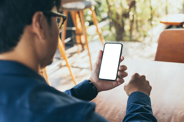 Wall Mural - cell phone blank white screen mockup.man hand holding texting using mobile on desk at office.background empty space for advertise.work people contact marketing business,technology