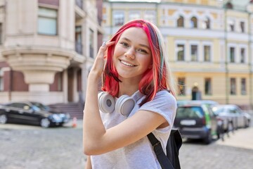 Fashionable smiling happy teen girl with bright dyed colored hairstyle on city