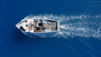 Wall Mural - Small Fishing boat sailing across calm smooth Sea, Aerial view.
