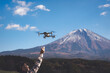 Hand catching drone aircraft in blue sky and Mt. Fuji background.
