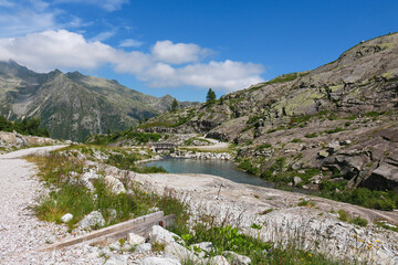 Ponte in legno che attraversa il fiume e bellissima vista sulle montagne dal sentiero che porta ai laghi Cornisello nella Val Nambrone in Trentino, viaggi e paesaggi in Italia