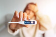 © Creative Cat Studio - Ill woman with a high fever showing thermometer with high body temperature 39.3
