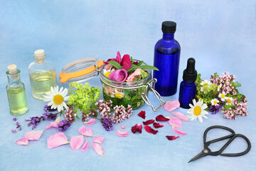 Sticker - Natural aromatherapy essential oil preparation with herbs & flowers for infusing in oils. Still life on mottled blue background. Health care concept for naturopathic herbal medicine.