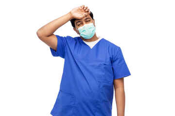 healthcare, profession and medicine concept - tired indian doctor or male nurse in blue uniform and face protective medical mask for protection from virus disease over white background